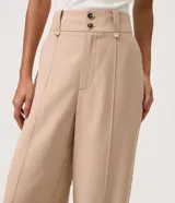 Pantalón wide leg de cintura alta y corte amplio, color beige, con doble botón frontal y bolsillos laterales.