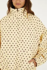 Campera reversible con estampado de lunares, cuello alto, cierre frontal y bolsillos laterales.