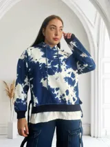 Buzo con capucha color azul y blanco con estampado tie-dye, de corte holgado y mangas largas.