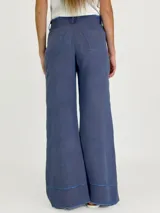 Pantalón palazzo color ladrillo, de tiro alto y corte amplio. Confeccionado en lino.