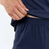 Conjunto de pijama corto de dos piezas para hombre, en color azul marino, compuesto por una remera de manga corta con pequeño estampado circular en el pecho y un short a juego con cordón ajustable en la cintura.
