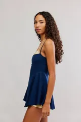 Vestido deportivo corto de color negro, con diseño fluido, tirantes finos y escote recto, ideal para tenis o actividades al aire libre.