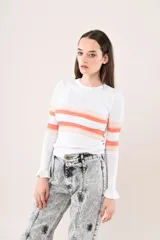 Remera de punto blanco con rayas horizontales en tonos naranja y nude en el pecho y las mangas largas. Presenta cuello redondo y puños con volados sutiles.