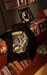 Remera de algodón premium con calce oversize, cuello redondo y mangas cortas. Presenta un estampado frontal gráfico con temática de Daft Punk en tonos verdes y violetas sobre fondo negro.