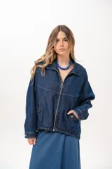Campera de jean azul de silueta relajada, con cuello clásico, cierre frontal con cremallera metálica y bolsillos laterales.
