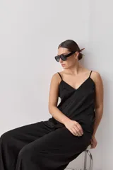 Top negro de breteles finos con escote en V y diseño minimalista, confeccionado en tela fluida y suave.