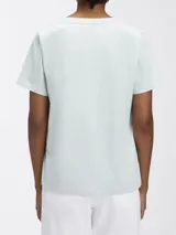 Remera Calvin Klein de manga corta y cuello en V, color verde menta pálido. Presenta una etiqueta con el logo de la marca en la parte posterior del cuello.