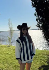 Sweater de lana color crema con rayas verticales anchas color amarillo mostaza, de corte holgado y cuello redondo. Tejido a mano.