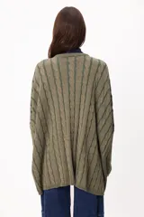 Sweater de tejido artesanal con diseño de rayas verticales en tonos camel y beige, corte holgado, cuello redondo y puños altos ajustados.
