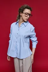 Camisa de manga larga color blanco, con cuello clásico y cierre frontal de botones de nácar. Presenta un corte cómodo y versátil.