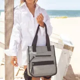 Mochila y cartera híbrida confeccionada en nylon de color beige con detalles y correas en negro. Posee dos asas superiores para llevar al hombro y correas traseras ajustables para usar como mochila. Presenta dos bolsillos frontales con cierre de cremallera y tiradores largos.