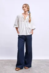 Camisa blanca de mangas 3/4 con detalle de encaje en el frente.