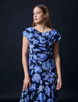 Vestido midi de gasa con estampado floral azul sobre fondo negro, torso drapeado y forro interno a tono.
