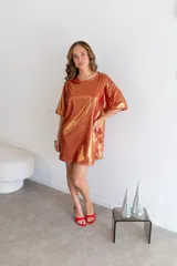 Remerón de manga corta, corte oversize, color naranja cobrizo con acabado metalizado y textura acanalada.