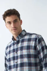 Camisa de viyela a cuadros azul, celeste y rojo, de corte regular, manga larga, con bolsillo en el pecho y logo bordado.