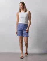 Short de gabardina elastizada con estampado floral en tonos azules, rosas y violetas. Pretina ancha elastizada y bolsillos delanteros.