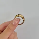 Anillo dorado de acero con diseño torneado.