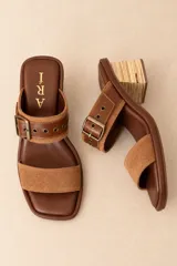 Sandalias de cuero vacuno negro con textura efecto cocodrilo, punta cuadrada y taco bloque. Presentan una tira ancha con hebilla metálica plateada y ojalillos decorativos.