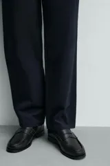 Mocasín de vestir para hombre confeccionado en piel con acabado abatanado, de color marrón. Cuenta con detalle de antifaz en el empeine, horma redonda, plantilla interior de piel y suela a contraste con ligero tacón.