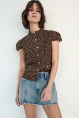 Falda pantalón de tiro medio confeccionada en denim, con bolsillos delanteros y cierre frontal con cremallera y botón metálico.