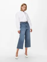 Jean de corte wide leg y tiro alto, con diseño cropped y terminación deshilachada en el ruedo. Confeccionado en denim elástico con cinco bolsillos y cierre frontal con botón metálico.