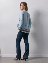 Blusa celeste de gasa bordada, con escote en V y lazo de ajuste. Mangas largas con terminación amplia.