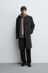 Abrigo regular fit de color negro, confeccionado con mezcla de lana y cashmere. Presenta cuello con solapas de muesca, manga larga, bolsillos de vivo en la cadera, abertura central en la espalda y cierre frontal de botonadura con tres botones.
