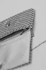 Bandolera pequeña de malla metálica en color cobre, con solapa frontal y cadena larga plateada para llevar al hombro o cruzada.