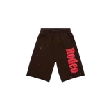 Bermuda de felpa color marrón, con cintura elástica, estampa con la palabra "Rodeo" en color rojo y detalles de pequeñas estrellas brillantes distribuidas en el diseño.