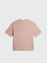 Remera de algodón color salmón, de corte holgado y cuello redondo con detalle de desgaste en el borde.