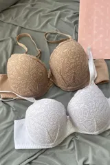 Conjunto de dos soutiens con aro y copa preformada, confeccionados en encaje floral color beige y blanco. Cuentan con breteles anchos regulables y espalda ancha.