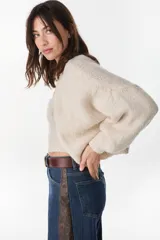 Cardigan crop de punto color crudo, con frente abierto sin botones y mangas largas abullonadas.