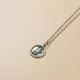 Collar de cadena de eslabones finos con dije circular de medalla religiosa de San Expedito, confeccionado en plata 925 con acabado envejecido.