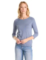 Buzo de tejido fino en color blanco, con cuello redondo y mangas raglán tres cuartos. Presenta una línea de tachas decorativas a lo largo de las mangas.