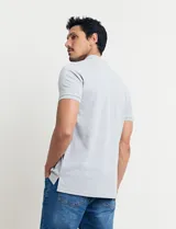 Remera tipo polo de color azul, con cuello clásico, cierre de botones y mangas cortas con terminación acanalada.
