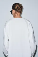 Camiseta blanca de algodón con escote en pico, manga larga y bajo recto.