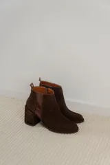 Botas cortas de cuero marrón con elástico lateral y tacón ancho.