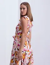 Vestido camisero midi estampado con flores en tonos rosa, naranja y marrón sobre fondo blanco. Tiene escote en V, abertura frontal con botones, mangas cortas con volados y lazo de ajuste en la cintura.