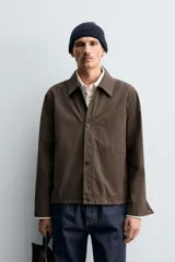 Sobrecamisa de corte regular fit confeccionada en tejido de algodón con acabado lavado. Presenta cuello solapa, cierre frontal de botones, mangas largas con puños abotonados y un bolsillo plastrón en el pecho.