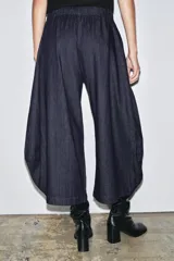 Pantalón ancho de denim azul oscuro, tiro medio, con cintura elástica ajustable mediante cordones interiores y pierna muy ancha con volumen que termina en un ruedo redondeado.