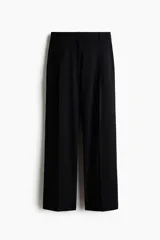 Pantalón ancho negro de corte holgado con pinzas, cierre frontal oculto y pliegues marcados en las piernas.