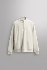 Sudadera gris claro de algodón con interior de rizo, cuello alto con cremallera, manga larga, bolsillos laterales y logo estampado en el pecho.