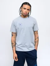 Remera de manga corta color blanco con cuello redondo. Presenta un pequeño logo circular de Umbro estampado en el pecho con la leyenda 'Born to Play'.