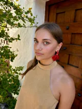 Caravanas colgantes de diseño floral en color rojo intenso, compuestas por una base de cuentas pequeñas y pétalos de resina en forma de flor.