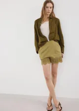 Short de tiro medio color verde militar, con pinzas, bolsillos laterales y delicados detalles bordados calados en el ruedo.