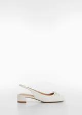 Zapato destalonado de efecto piel en color blanco, con punta redonda, lazo decorativo en el empeine y tacón bloque bajo.
