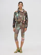 Calza deportiva 3/4 de tiro alto, confeccionada en lycra con un diseño estampado abstracto en tonos tierra, verdes y rosados.