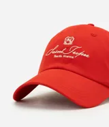 Gorra roja confeccionada en sarga de algodón, con visera curva y bordado frontal en tono claro con la inscripción "Saint Tropez South France" y un escudo. Cuenta con ojalillos de ventilación y ajuste posterior.