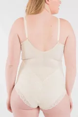 Body modelador reductor color crudo, con aro y detalles de puntilla. Breteles elásticos regulables y broche en la entrepierna.