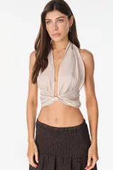 Top color blanco de lino italiano, con diseño de escote halter pronunciado, espalda descubierta y nudo frontal.